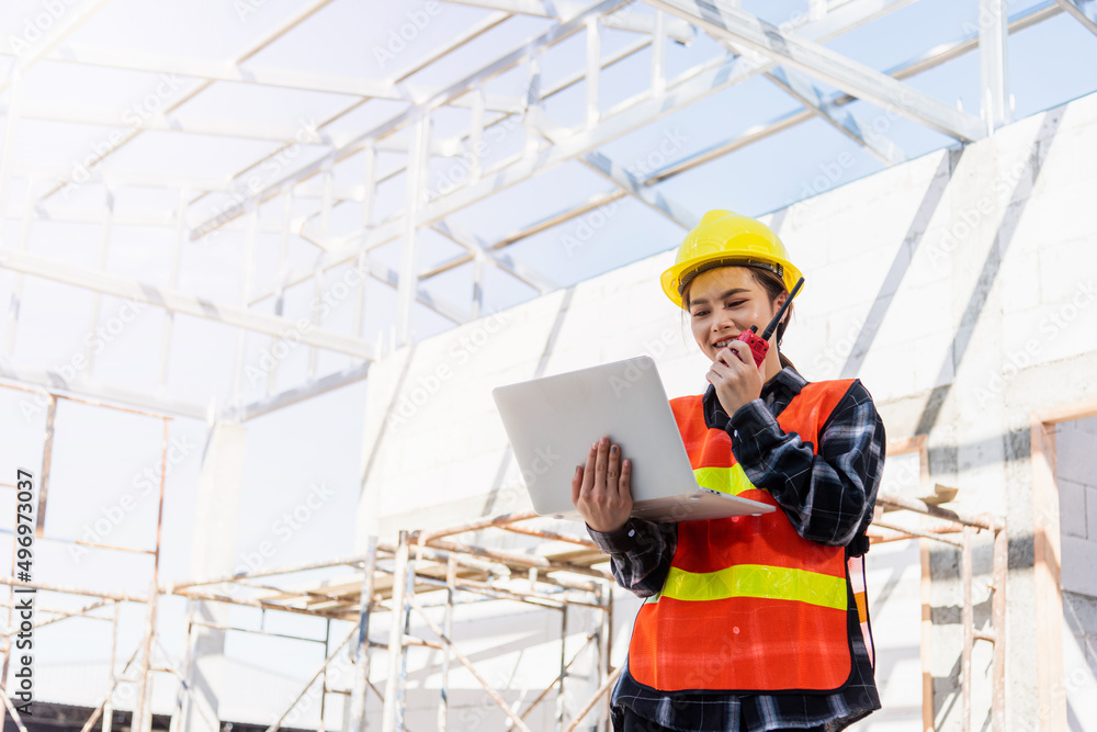 Asian engineer architect worker woman working at build construction site use laptop and talking with radio, engineering hold computer and radio discuss operate and control worker employee to building Asian engineer architect worker woman working at build construction site use laptop and talking with radio, engineering hold computer and radio discuss operate and control worker employee to building