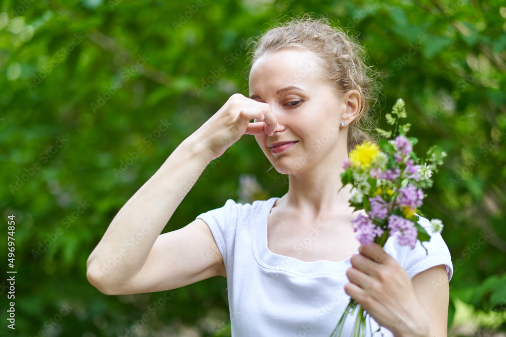Allergy. Woman squeezed her nose with hand, so as not to sneeze from the pollen of flowers Allergy. Woman squeezed her nose with hand, so as not to sneeze from the pollen of flowers