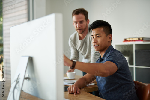 Sharing his ideas. Cropped shot of two designers working together on a project in an office.