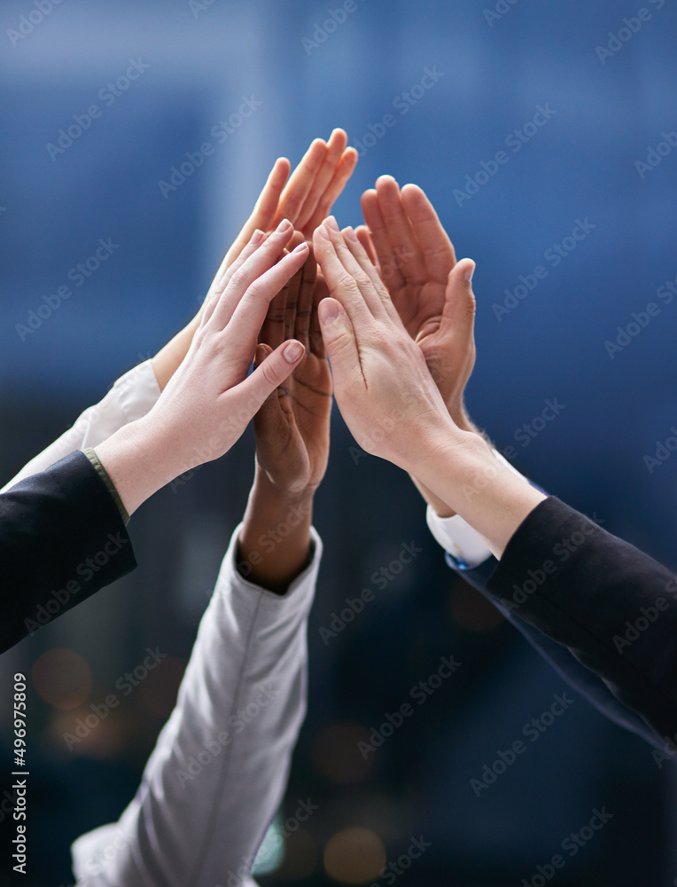 © Nola V/peopleimages.com - One team working towards one dream. Shot of a group of colleagues giving each other a high five in an office.