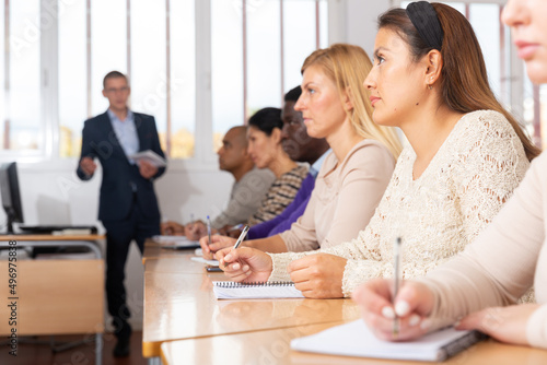 Portrait of confident woman sitting in class working during group business training