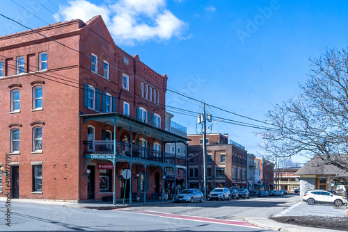 Warwick, NY - USA - April 2, 2022: Horizontal view of historic Railroad Avenue in downtown Warwick, location of Railroad Green, the iconic Demarest Building, many boutiques, shops, and restaurants.