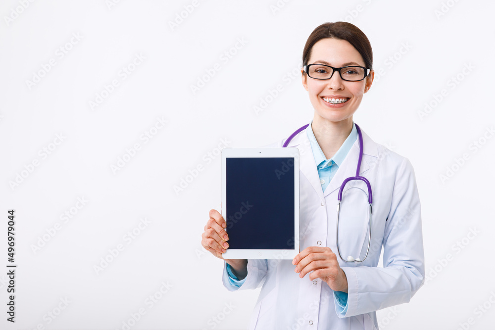 Cheerful young female doctor holding a clipboard in her hand and pointing to copyspace with a gesture Cheerful young female doctor holding a clipboard in her hand and pointing to copyspace with a gesture