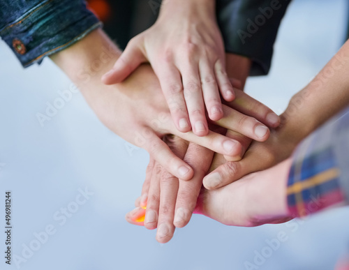 Making a pact to stay friends forever. Shot of a group of unidentifiable friends making a pact by putting their hands in a pile.