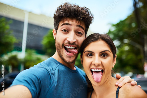 Lets snap some silly selfies before we start sweating. Portrait of a sporty young couple taking a selfie together outdoors.