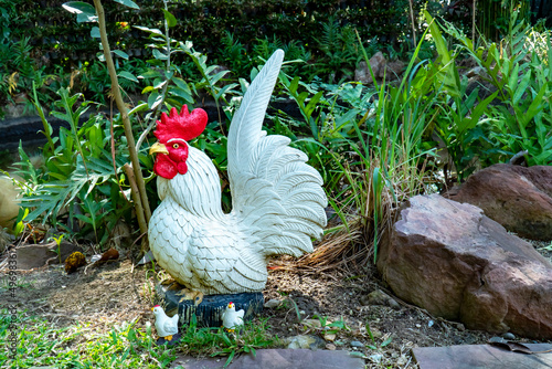 Fotobehang Decoration rooster statue with chick in the garden