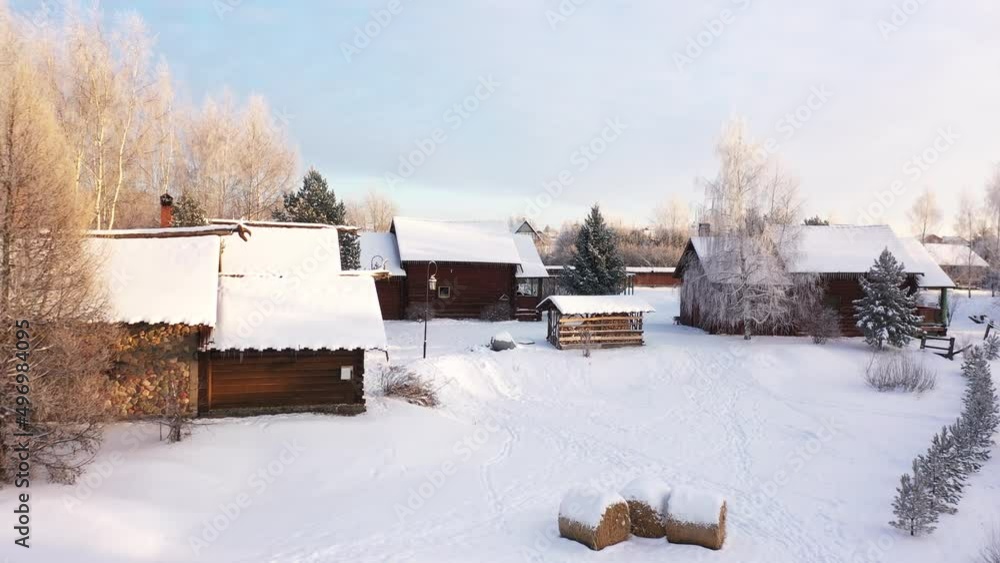 Russian village in winter, snow-covered roofs of wooden houses Russian village in winter, snow-covered roofs of wooden houses