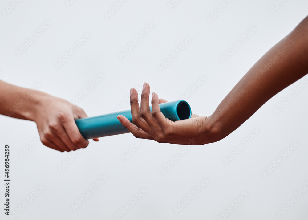 Nothing will stop us now. Shot of two athletes passing a baton during a relay race. - obrazy, fototapety, plakaty 