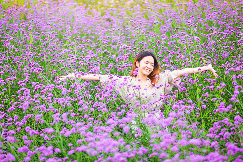 Attractive beautiful woman rise up her arms with happiness freedom in the middle of flower gardens Attractive beautiful woman rise up her arms with happiness freedom in the middle of flower gardens