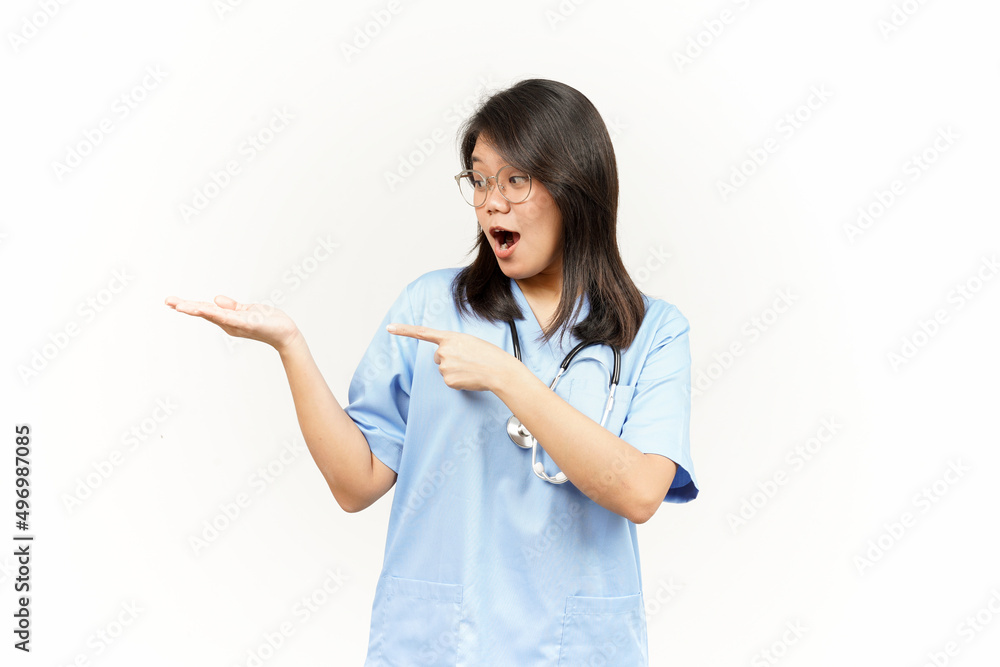 Showing and Pointing Product With Thumb Of Asian Young Doctor Isolated On White Background Showing and Pointing Product With Thumb Of Asian Young Doctor Isolated On White Background