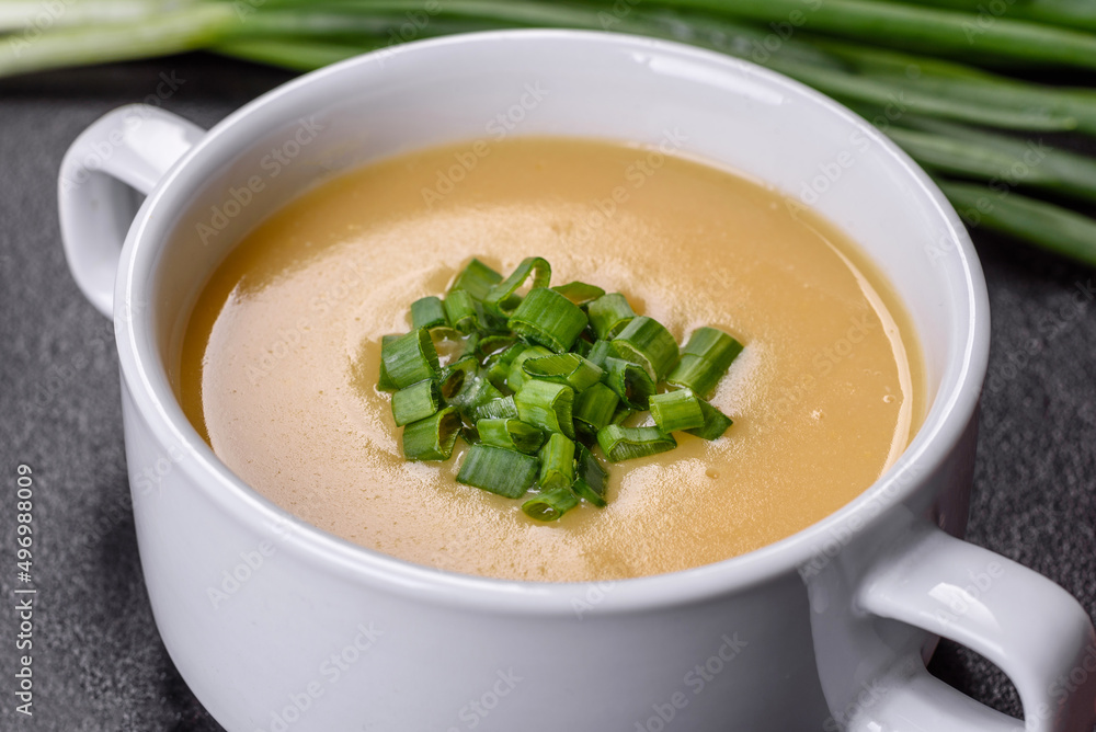 Cream soup with potatoes, leek and peas on a dark concrete table Cream soup with potatoes, leek and peas on a dark concrete table