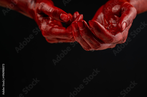 Women's hands in blood on a black background. © Михаил Решетников
