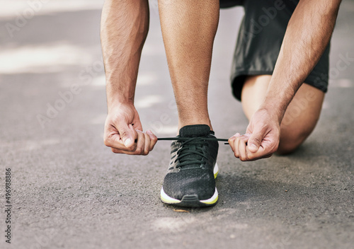 Ready to race. Shot of an unidentifiable young sportsman tying his shoelaces before a run.