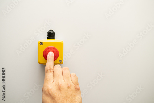 Stop Red Button and the Hand of Worker About to Press it. emergency stop button. Big Red emergency button or stop button for manual pressing. photo