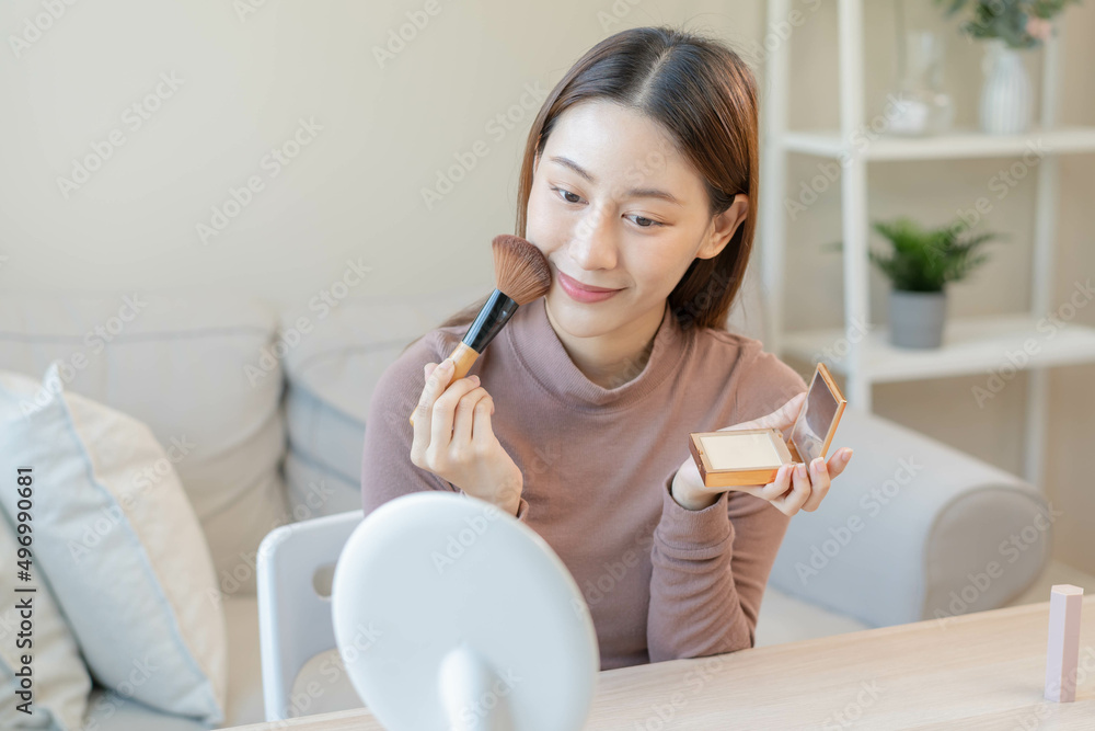Happy beauty blogger concept, pretty asian young woman, girl make up face by applying powder foundation by brush around face, looking at the mirror at home. Female look with natural fashion style. Happy beauty blogger concept, pretty asian young woman, girl make up face by applying powder foundation by brush around face, looking at the mirror at home. Female look with natural fashion style.