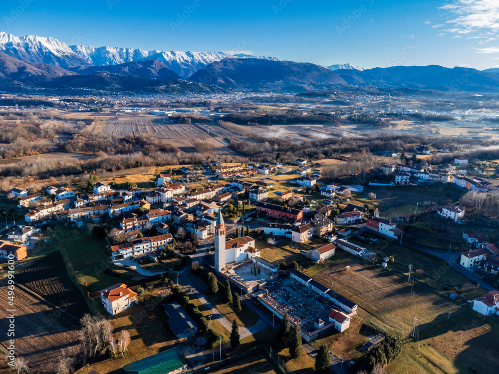 Central Friuli villages seen from above. Between hills and snow-capped mountains. Raspano di Cassacco.