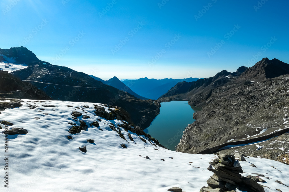 Obraz premium Panoramic view on the mountains of Hohe Tauern Alps in Carinthia, Austria, Europe. A lake reflection and water reservoir on the Moelltaler glacier. Hohe Tauern National Park. Valley in the shadow