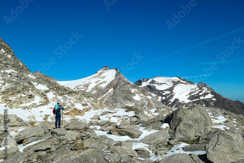 Hiking woman with scenic view on Hoher Sonnblick in High Tauern mountains in Carinthia, Salzburg, Austria, Europe, Alps. Snowy and rocky terrain, Goldbergkees in Hohe Tauern National Park. Patagonia