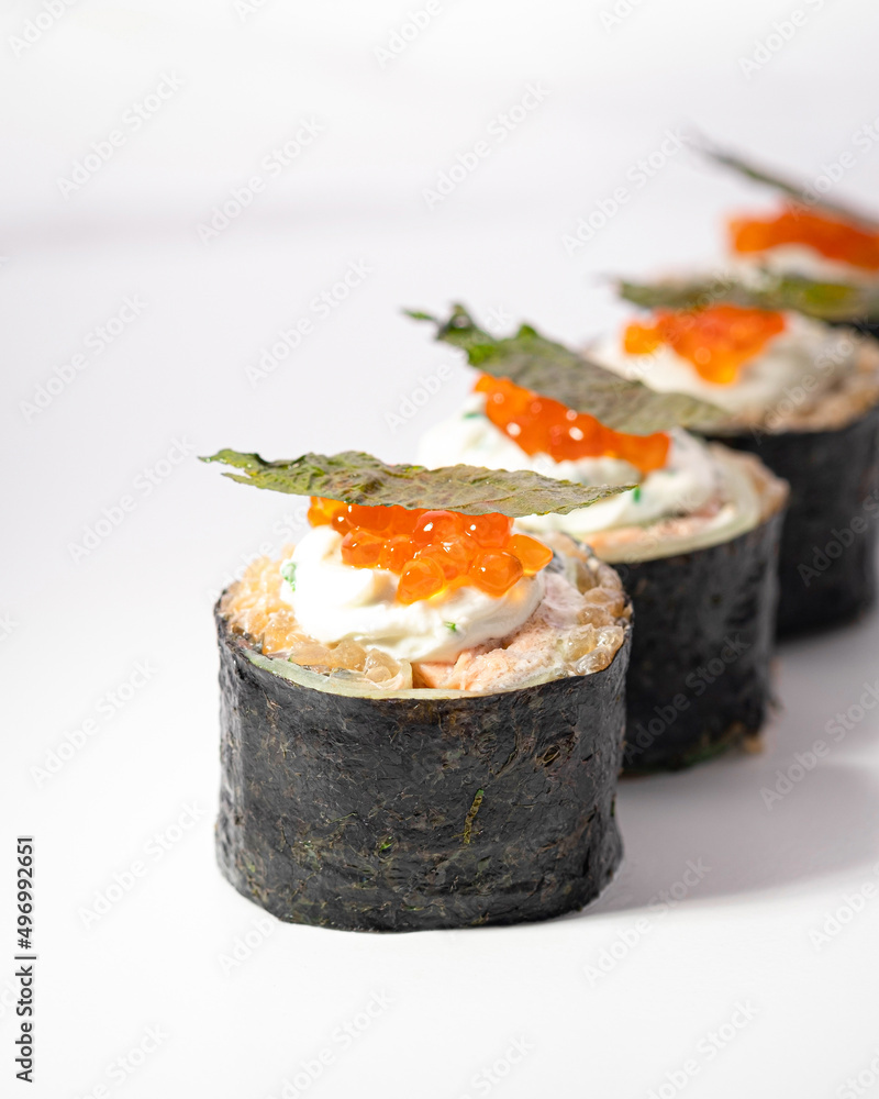 Sushi maki roll on white background. Macro close up of low-carb KETO sushi with shirataki rice and caviar. Ketogenic diet, without rice. Japanese cuisine restaurant menu. Vertical, selective focus Sushi maki roll on white background. Macro close up of low-carb KETO sushi with shirataki rice and caviar. Ketogenic diet, without rice. Japanese cuisine restaurant menu. Vertical, selective focus