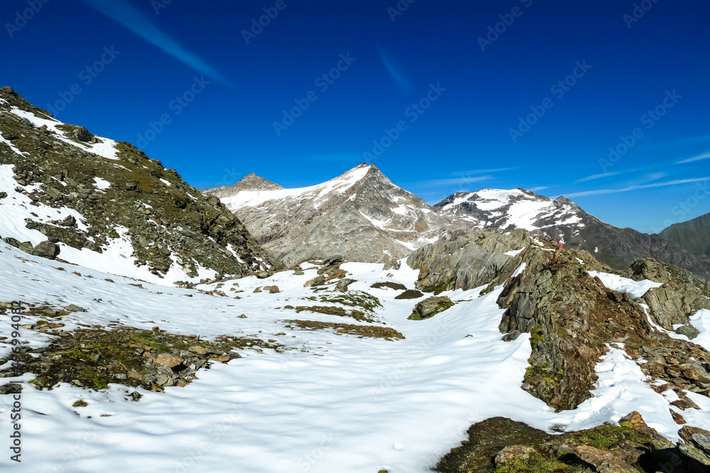 A field of snow covered rocks in the Hohe Tauern Alps in Carinthia, Austria, Europe. Rock formations with view on Hoher Sonnblick in the Hohe Tauern National Park. Hiking trail of the Tauern Hoehenweg