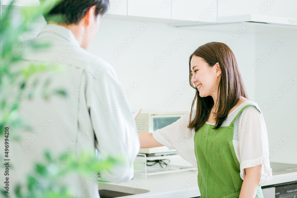 キッチンで話す作業着姿の男性と女性(水道・笑顔)
キッチンで話す作業着姿の男性と女性(水道・笑顔)