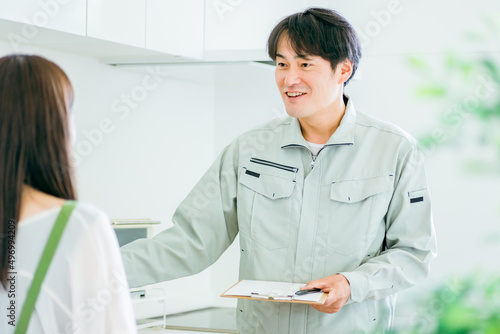 キッチンと作業着姿の男性（水道・笑顔） 