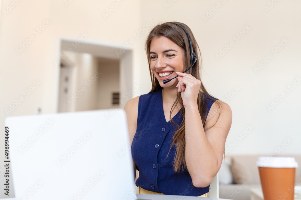 Happy young woman in headphones speaking looking at laptop making notes, business woman talking by video conference call, Conference by webcam, online training, e-coaching concept Happy young woman in headphones speaking looking at laptop making notes, business woman talking by video conference call, Conference by webcam, online training, e-coaching concept