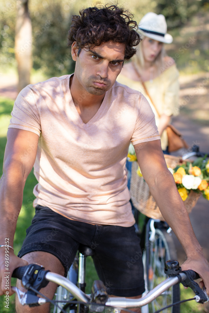 sad and angry couple sitting on a bike