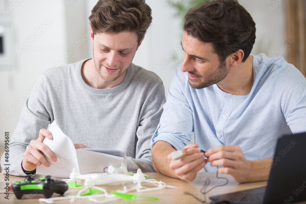 two male friends assembling a drone two male friends assembling a drone
