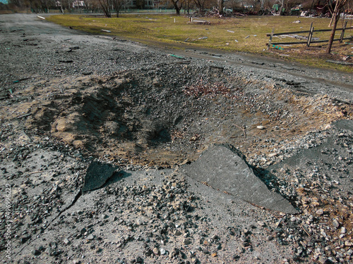 Crater on the road after the explosion of a Russian rocket