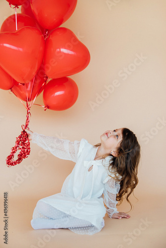 Cute little girl with heart shaped balloons on Valentine's day. family, love. gifts for the holiday.