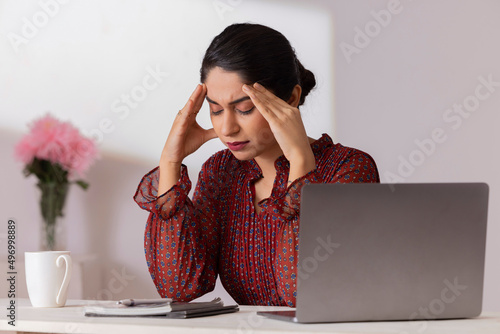 Φωτογραφία Portrait of an exhausted working woman with laptop in office