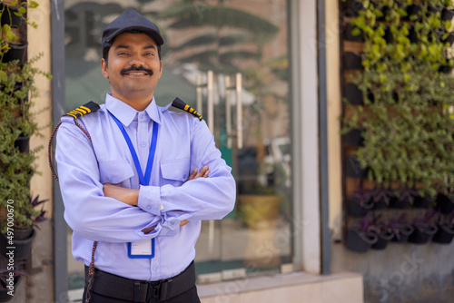 Fotografija Portrait of security guard with arms folded while working at gate