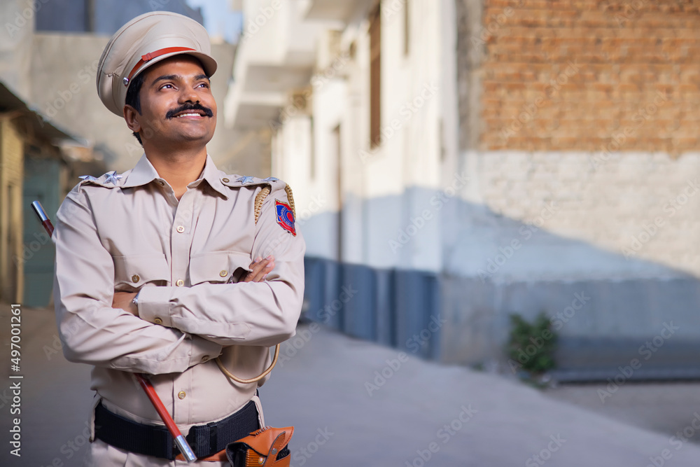 Portrait of an Indian policeman looking elsewhere with arms folded Portrait of an Indian policeman looking elsewhere with arms folded