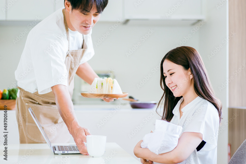Obraz premium 出産後に仕事する女性と家事をする男性 