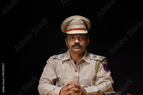 Portrait of an Indian policeman sitting in policestation photo