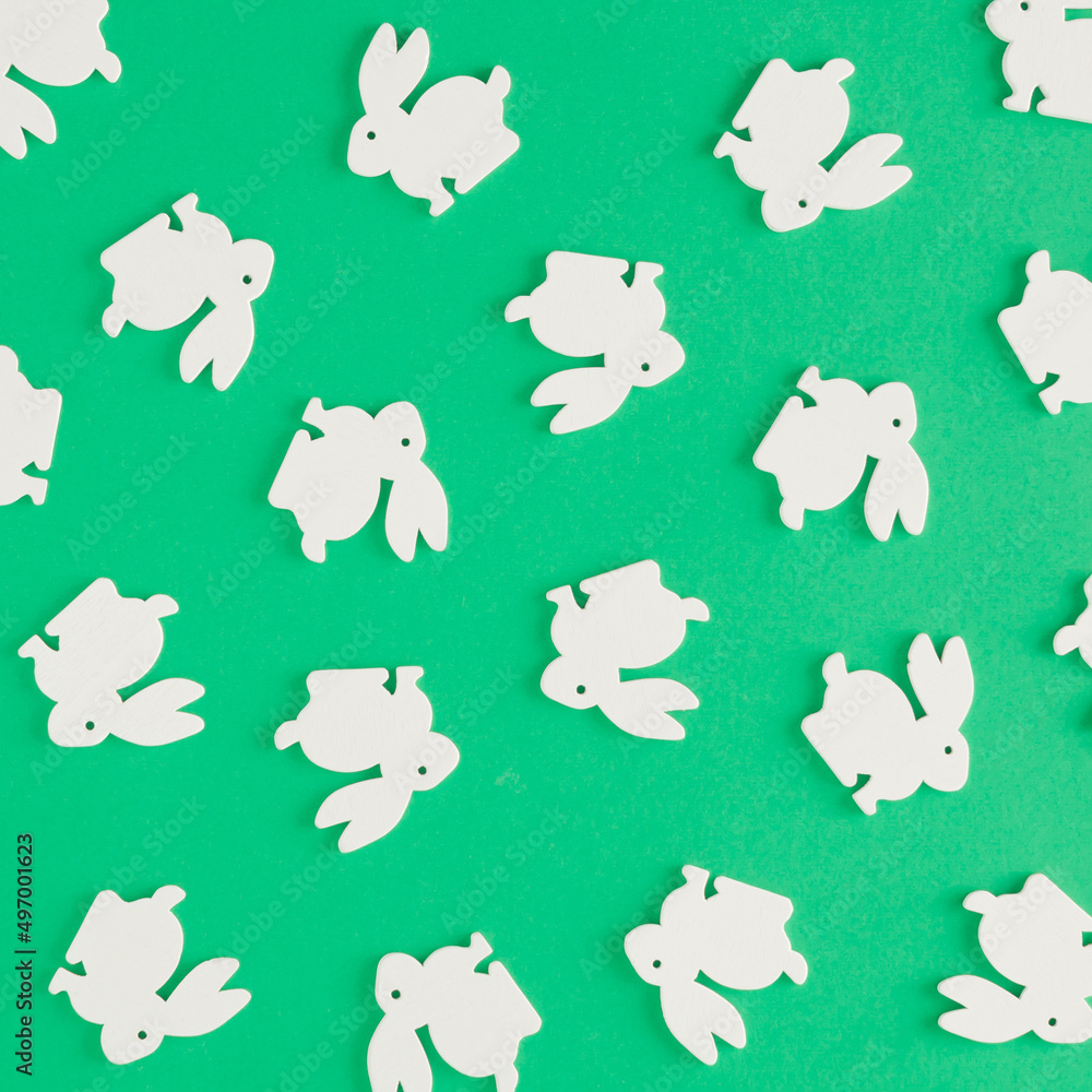 Creative pattern made of white rabbits on a green background. Minimal flat lay concept. Easter inspiration.