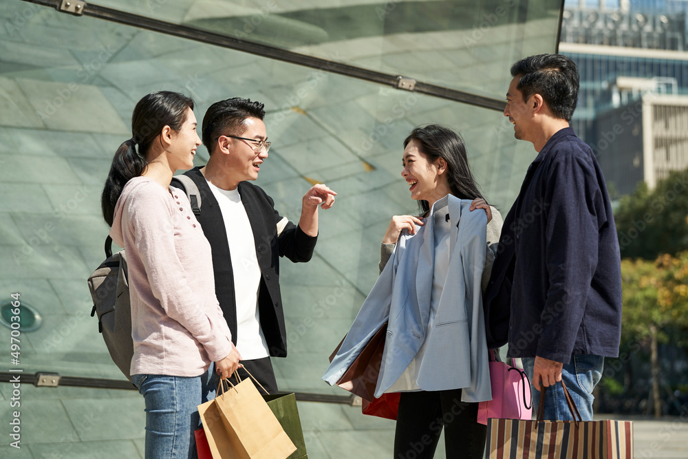group of young asian people talking chatting conversing during shopping trip group of young asian people talking chatting conversing during shopping trip