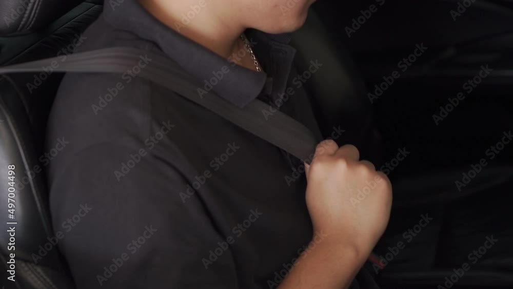 The driver did not know how to fasten the seat belt in the car. side view A young Asian man clicks his seat belt before driving. mindful driving concept The driver did not know how to fasten the seat belt in the car. side view A young Asian man clicks his seat belt before driving. mindful driving concept