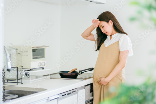妊娠中に体調不良になる女性（頭痛・発熱）
 photo