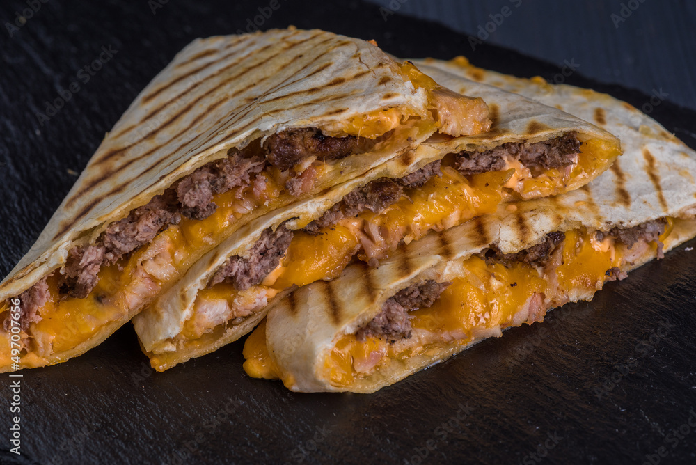 Quesadilla with beef. Tortilla, beef, cheese, white onion, cheese sauce.