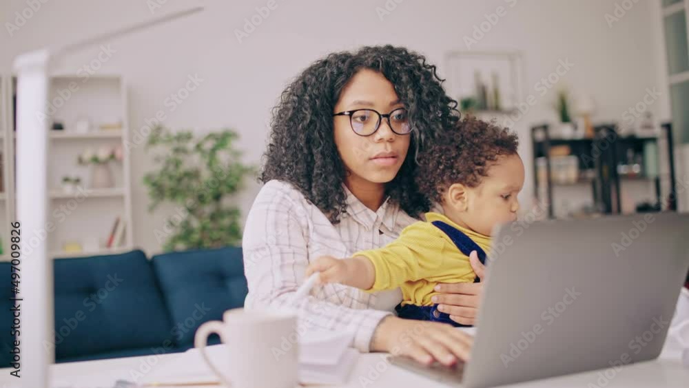 Working mom having online video call with a baby on her lap, work-life balance Working mom having online video call with a baby on her lap, work-life balance