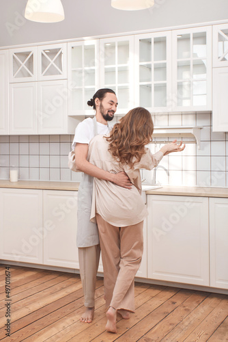 Beautiful young couple is dancing and smiling together in kitchen © Наталья Вторушина