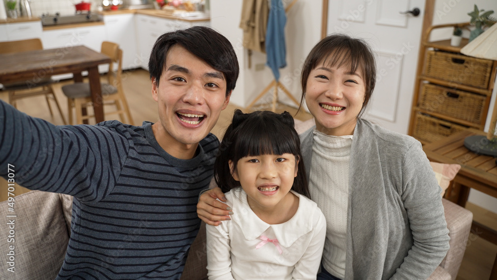 mobile cam view of happy asian dad, mom and daughter enjoying chatting with friends through video call. they look at camera and introduce the girl with smile mobile cam view of happy asian dad, mom and daughter enjoying chatting with friends through video call. they look at camera and introduce the girl with smile