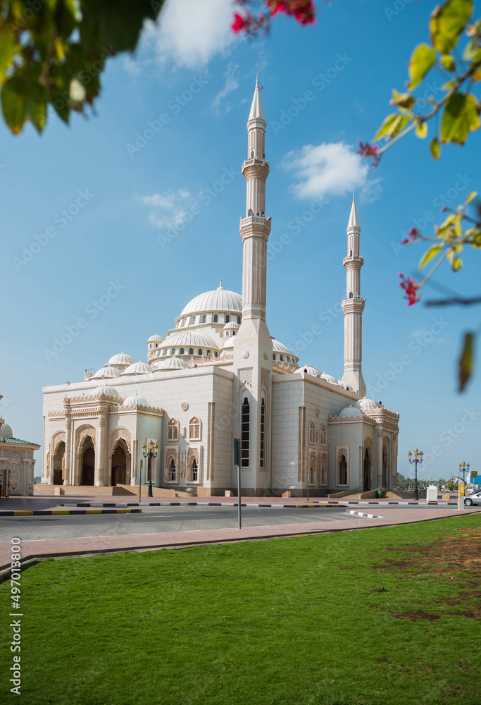 Beautiful Al Noor Mosque located at Sharjah corniche. A view of a Masjid against blue sky.