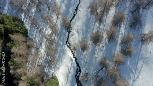 drone flying above the mountains during winter, forward movement tilting up photo