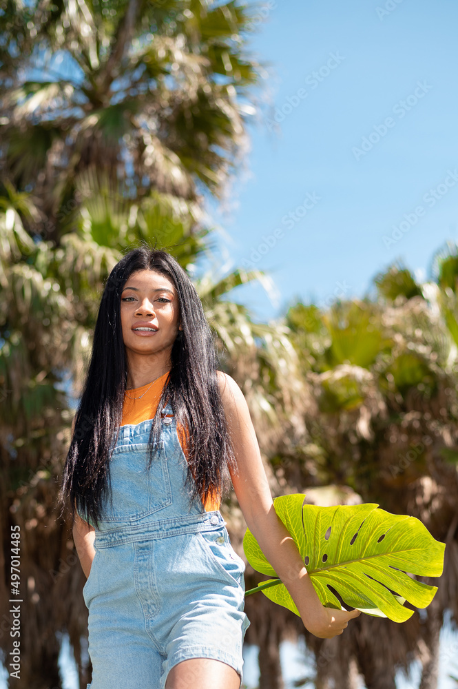 Portrait of an African American woman next to some palm trees on a sunny day on vacation Portrait of an African American woman next to some palm trees on a sunny day on vacation