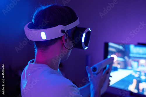 Man with virtual reality headset and joystic is playing game