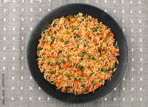 Schezwan Fried Rice is a popular indo-chinese food served in a plate or bowl with authentic sausages. selective focus photo