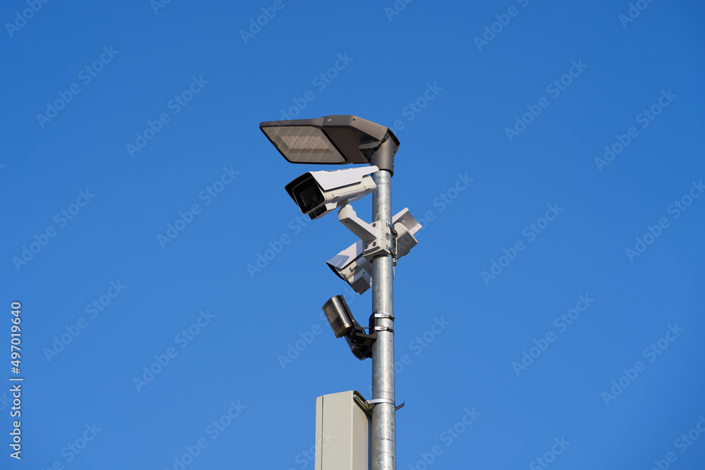 Security cameras on a pole against a blue sky. Security cameras on a pole against a blue sky.